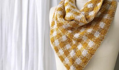 Элегантный шерстяной шарф с уникальным узором в виде золотистых и белых гусиной лапки, создающий эффект объемных геометрических фигур.