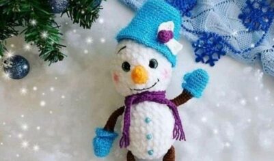 Зимняя забавная кукла-снеговик с ярким шарфом и шапкой.