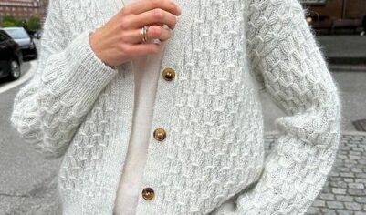 Уютный вязаный кардиган с крупной текстурой и контрастными пуговицами, напоминающими старинные деревянные бусы.
